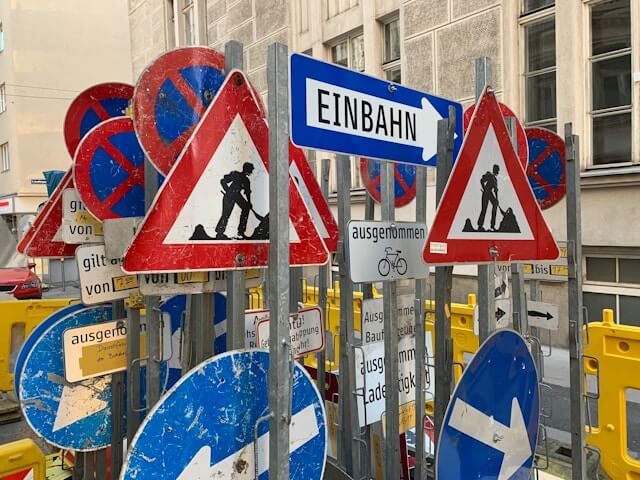 A bunch of street signs point in all different directions with different messages.