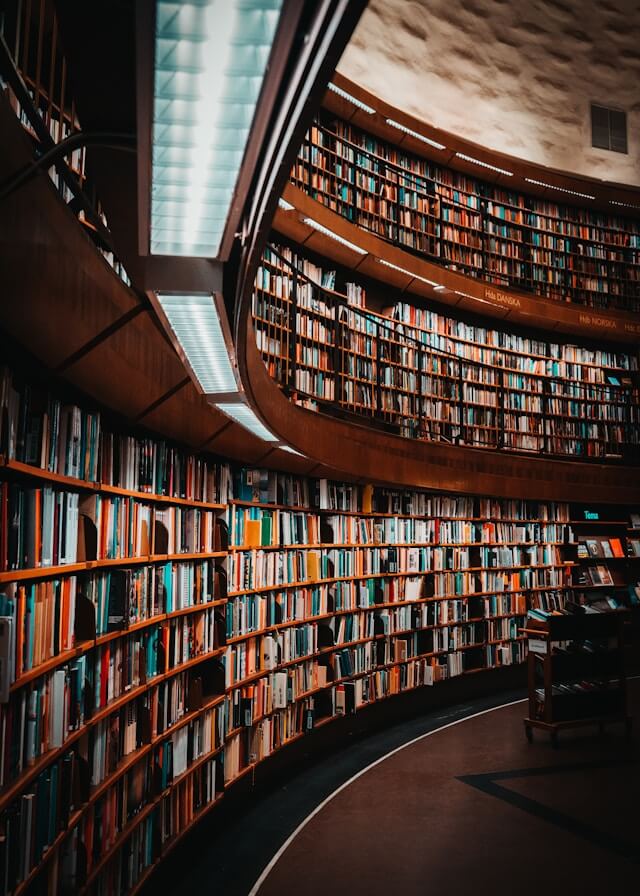 A curving library filled with books on three stories.