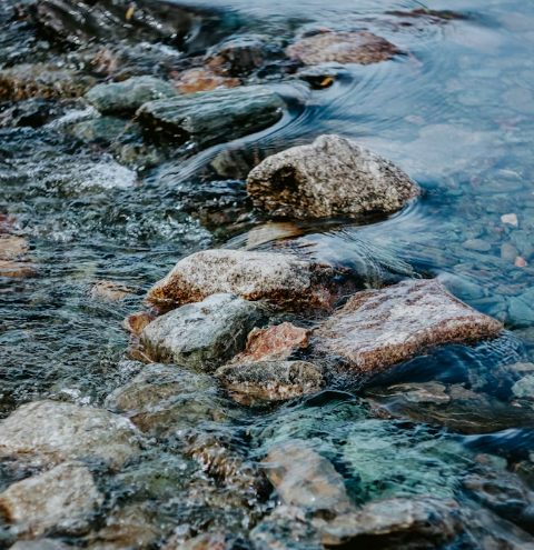 Close up of water flowing through rocks in a stream.